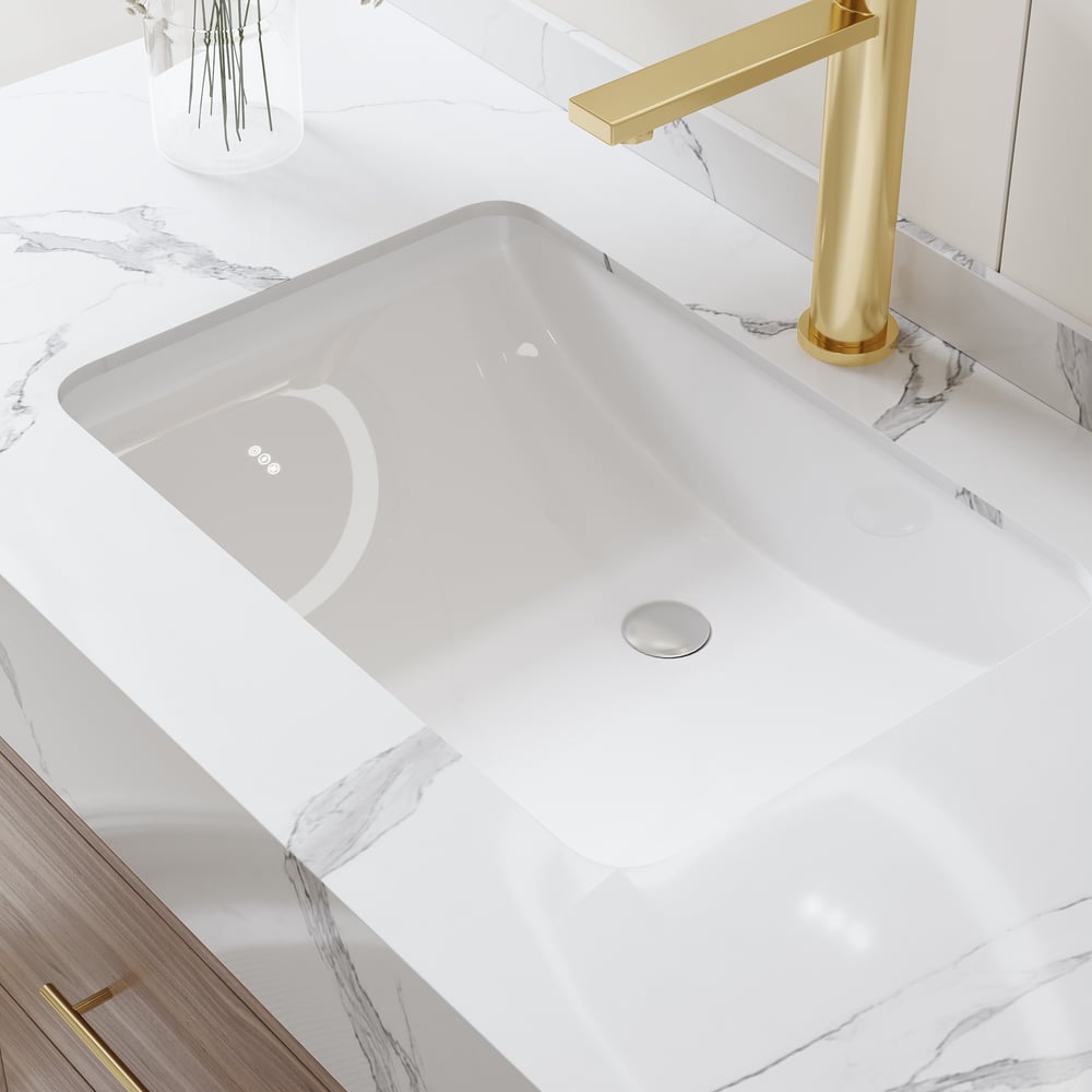 Gray undermount sink with gold faucet on a marble countertop