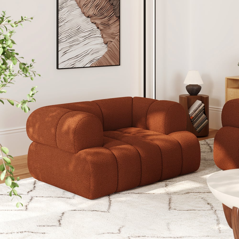 Brown modular sofa in a living room setting with a plant and artwork on the wall.