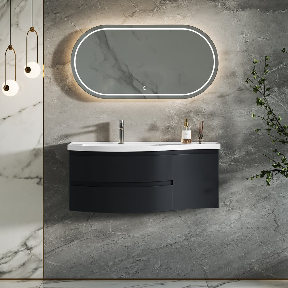 Bathroom vanity with black cabinet, white sink, and oval mirror on a gray marble wall.