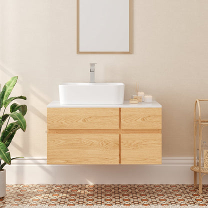 Bathroom vanity with wooden cabinet and white countertop, featuring a mirror and decorative items.