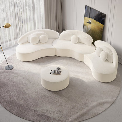 Modern white sectional sofa with a round ottoman on a gray rug.