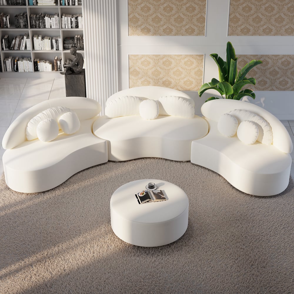 Modern white sofa set with a round ottoman in a living room setting.