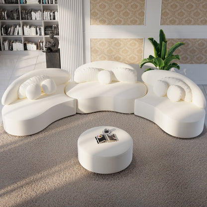 Modern white sofa set with a round ottoman in a living room setting.