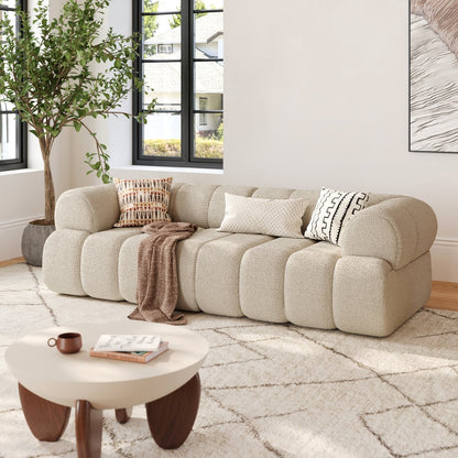 Beige sectional sofa in a living room with a coffee table and decorative items.