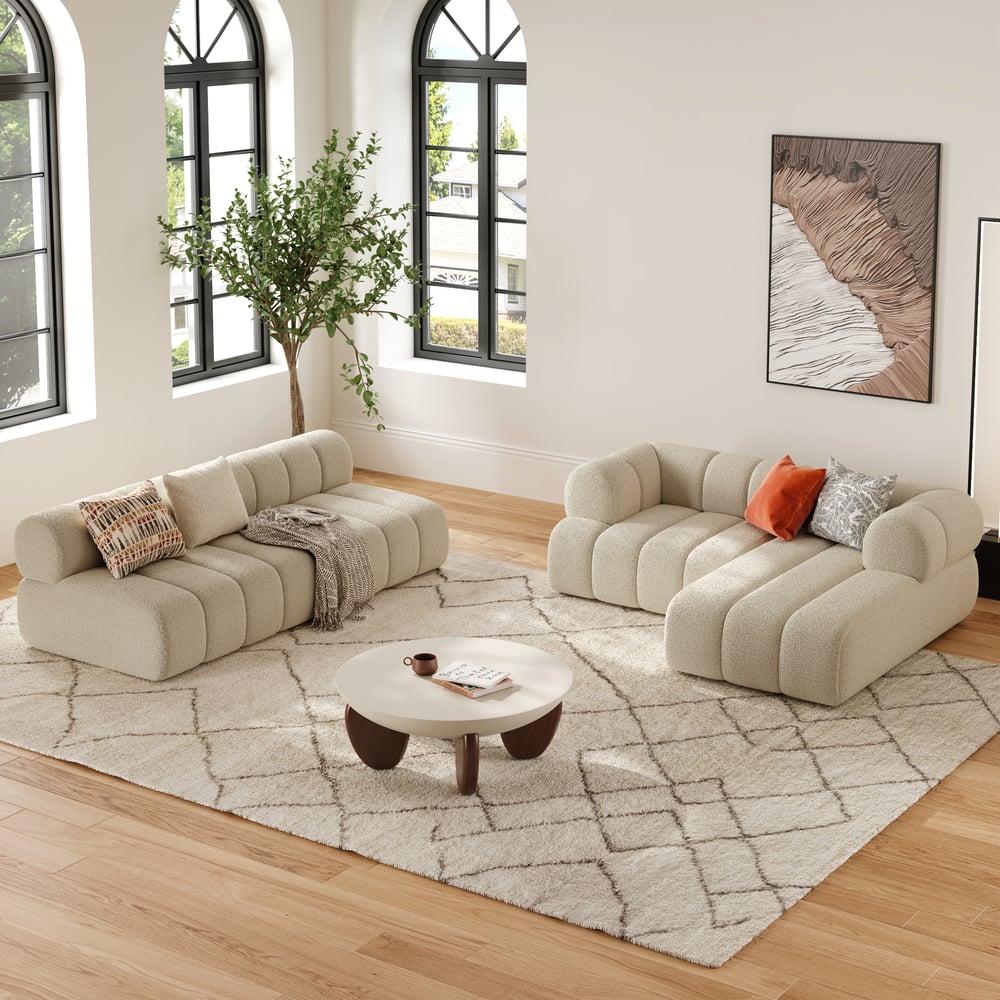 Modern living room with beige sofa set, coffee table, and decorative elements.
