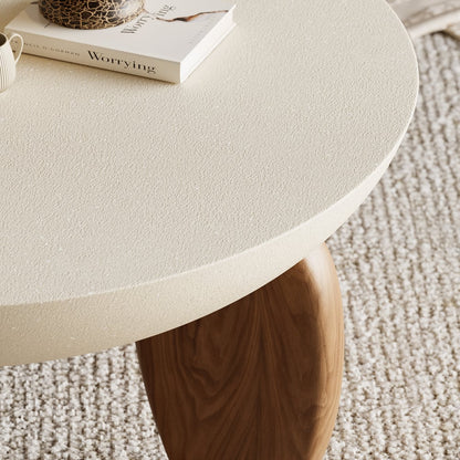 Round beige table with a wooden leg on a textured carpet
