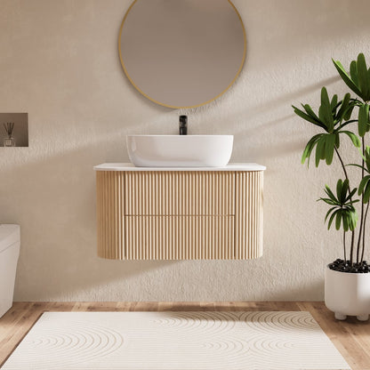 Bathroom with wooden vanity, white sink, and plant on a beige wall.