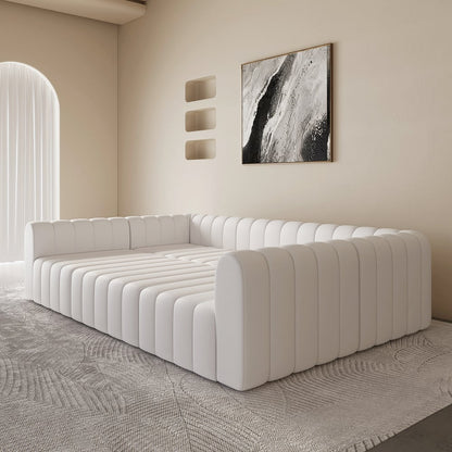 Modern white sofa in a minimalistic room with abstract art on the wall.