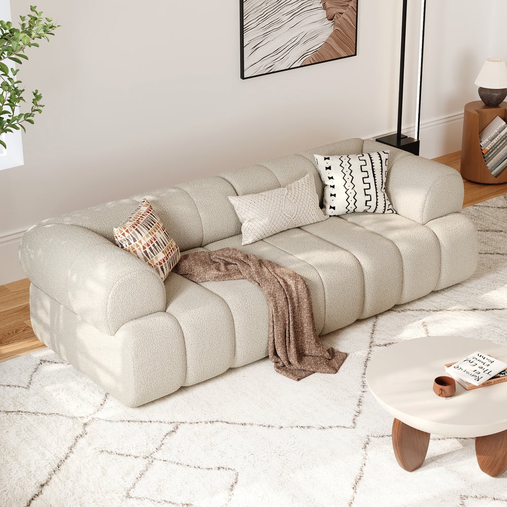 Beige sectional sofa in a living room with a coffee table and decorative pillows.