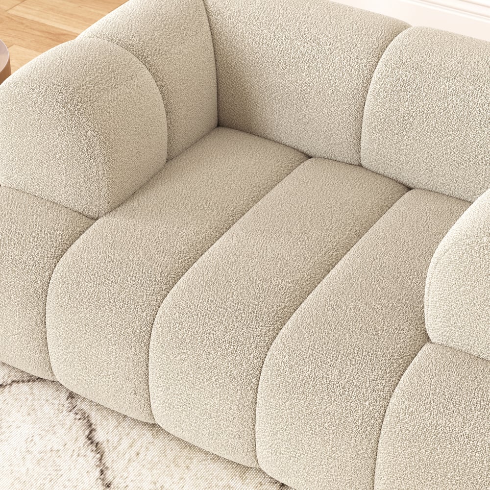 Close-up of a textured beige sofa with tufted design.