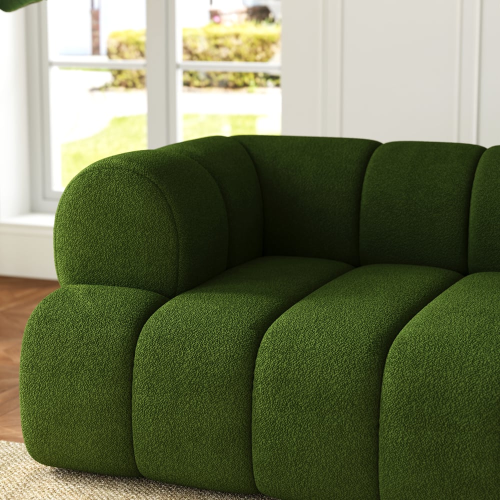 Green sofa in a room with a window in the background