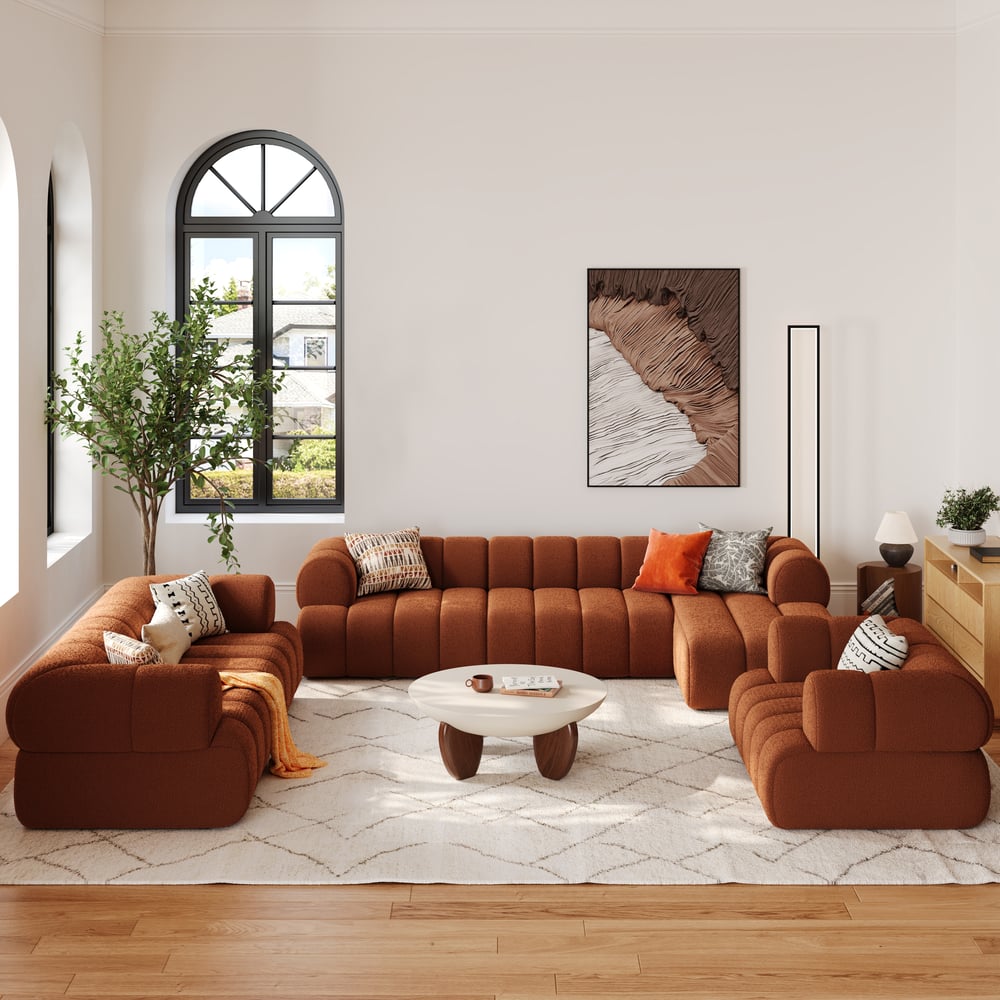 Modern living room with brown sectional sofa, coffee table, and decorative pillows.