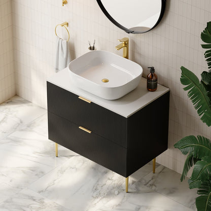 Modern bathroom vanity with white sink, black cabinet, and gold fixtures.