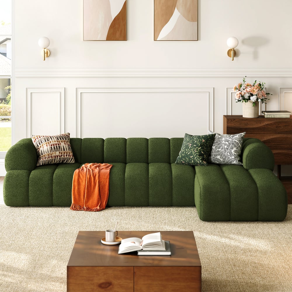 Green sofa with decorative pillows and a wooden coffee table in a living room setting.