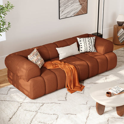 Brown sofa with decorative pillows and a blanket in a living room setting.