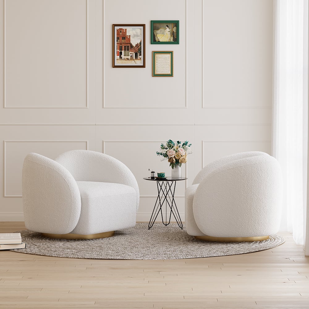 Two white armchairs in a room with a small round table and decorative elements.