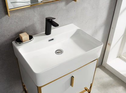 Bathroom vanity with white sink and gold accents, featuring a black faucet.