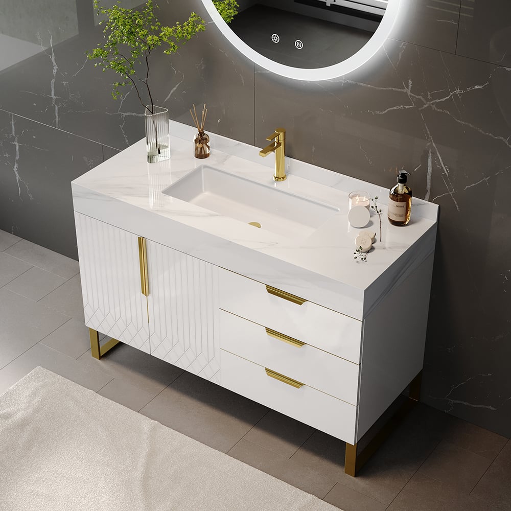 Bathroom vanity with white countertop, gold fixtures, and decorative items.