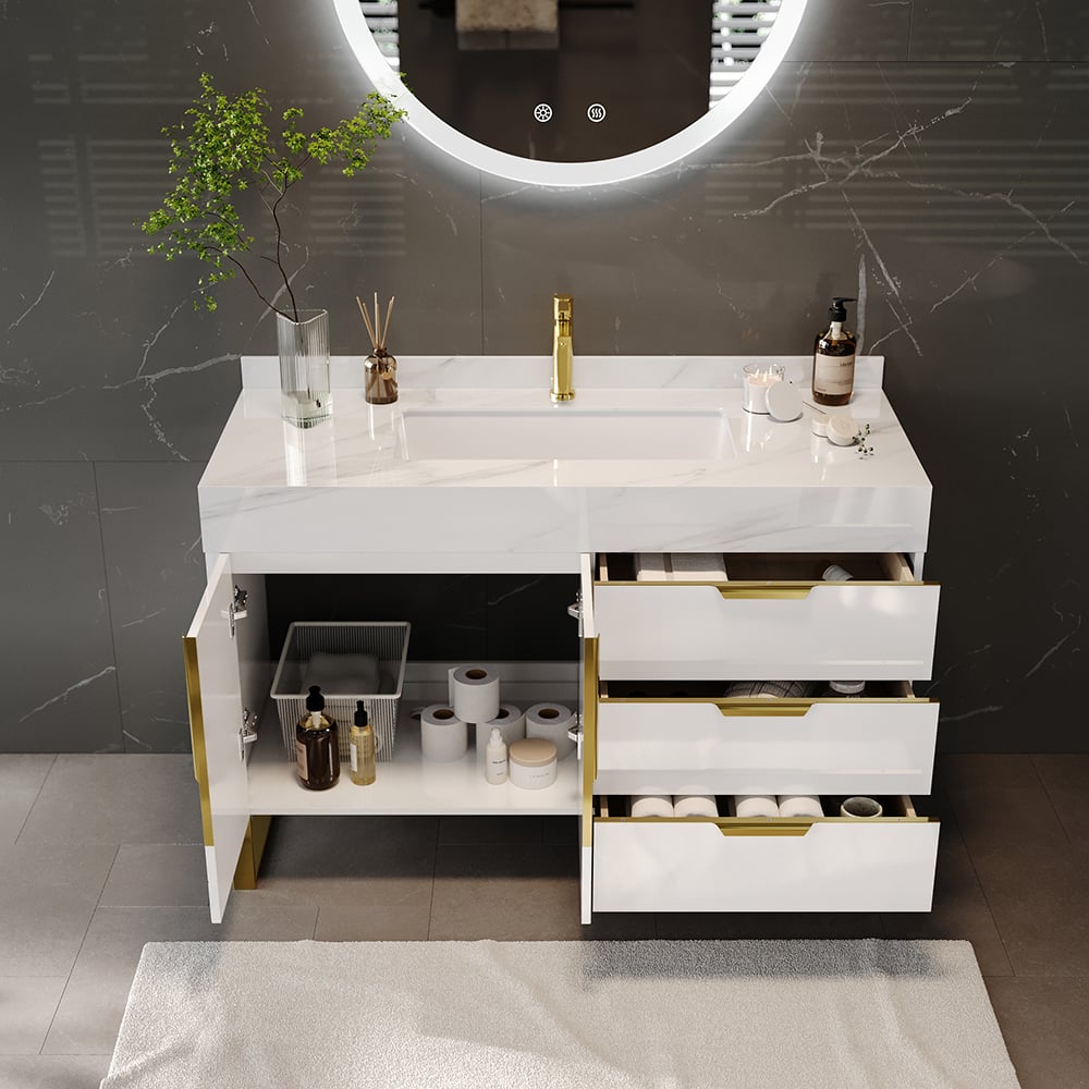 Bathroom vanity with white countertop, gold fixtures, and open drawer revealing storage.