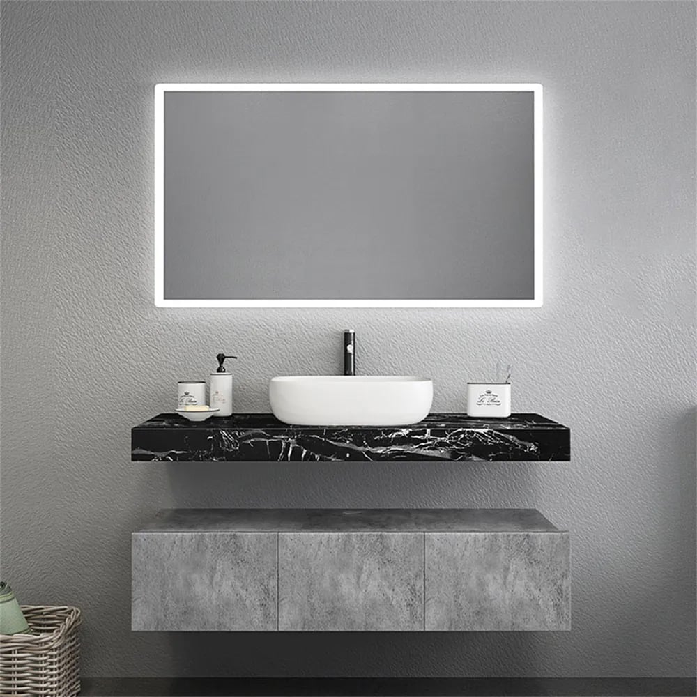 Bathroom vanity with a sink and illuminated mirror on a gray wall.