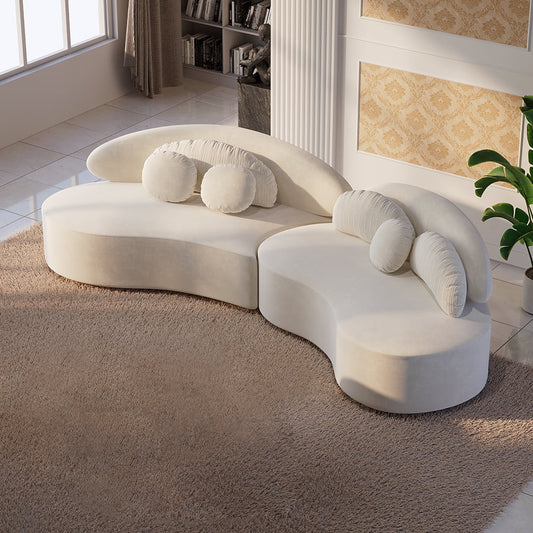 Modern white curved sofa with decorative cushions in a living room setting.