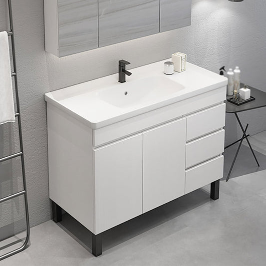 Bathroom vanity with white countertop and black faucet in a modern bathroom setting.