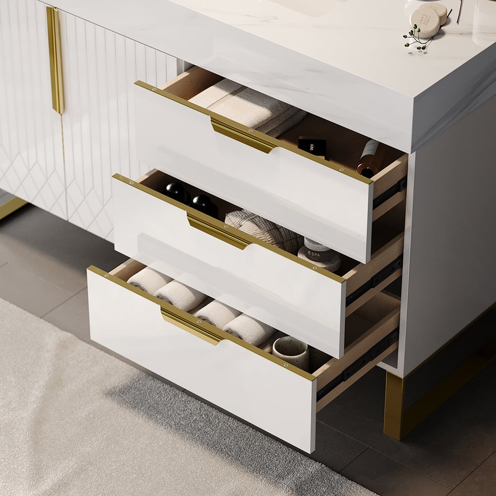 White dresser with gold accents and open drawers revealing interior organization.