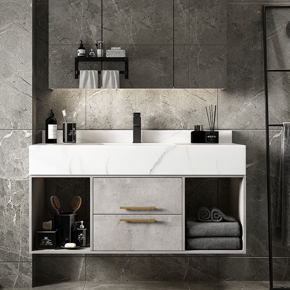 Bathroom vanity with marble countertop and gray tiles on the wall.