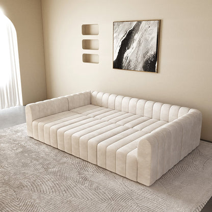 Off white tufted sofa in a room with abstract art on the wall.