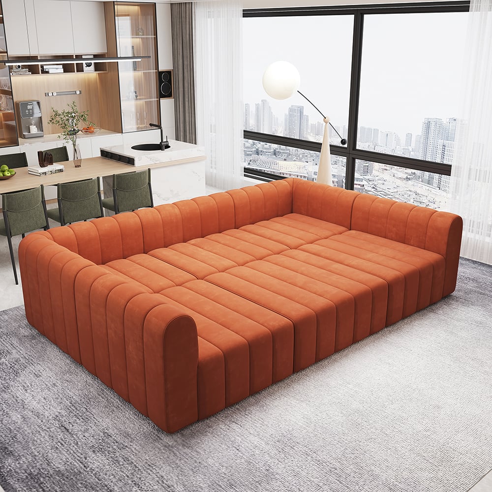 Orange sectional sofa in a modern living room with a kitchen in the background.