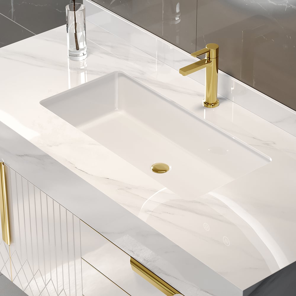 Bathroom vanity with a white sink and gold faucet