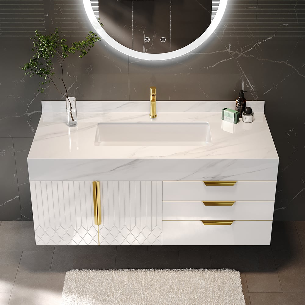 Bathroom vanity with marble countertop, sink, and gold fixtures against a gray wall.