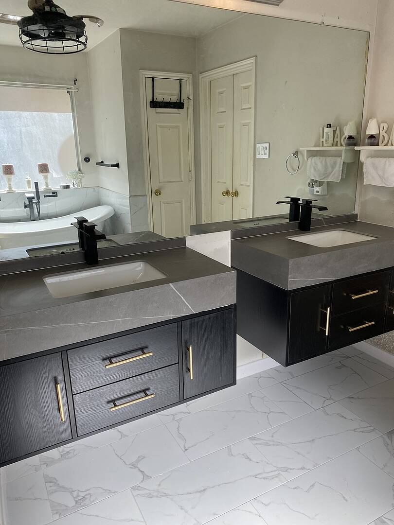 Bathroom with double vanity, mirrors, and decorative items.