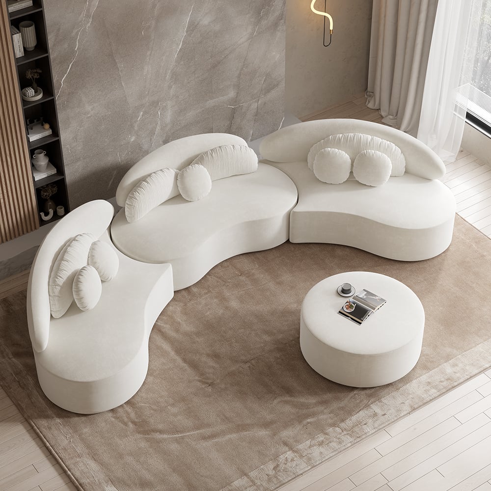 Modern white sofa set with round ottoman in a room with marble walls and floor.