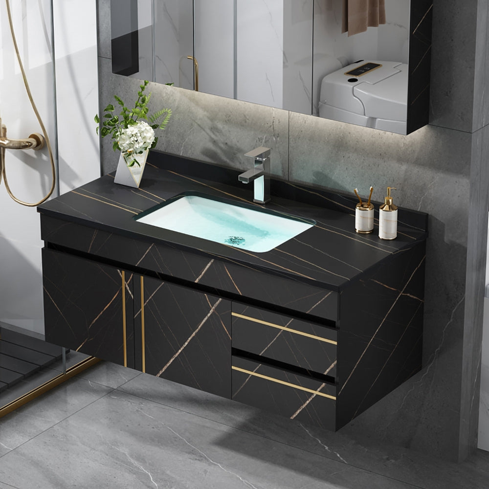 Bathroom vanity with black marble countertop and sink, featuring gold accents.
