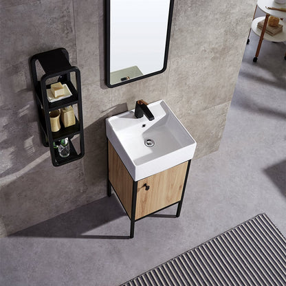 Bathroom vanity with white sink, wooden cabinet, and black shelf against a gray tiled wall.