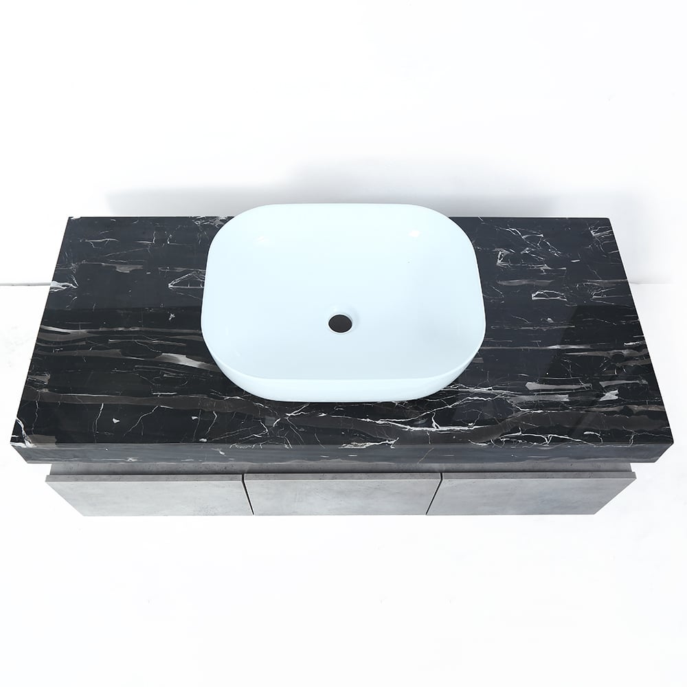 Black marble vanity top with a white sink on a white background