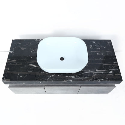 Black marble vanity top with a white sink on a white background