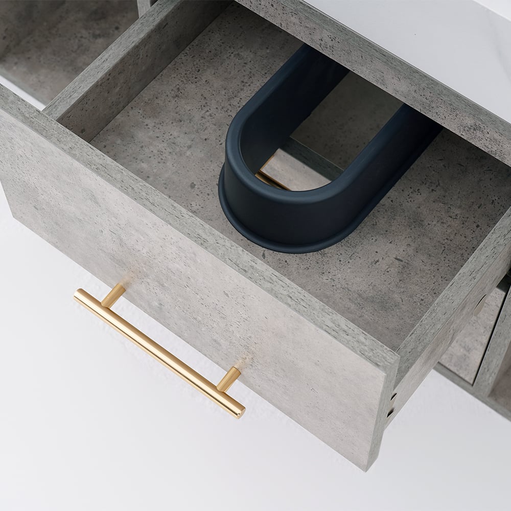 Open drawer with concrete interior and gold handle on a white background