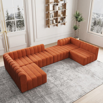 Orange sectional sofa in a modern living room with a bookshelf and plants.