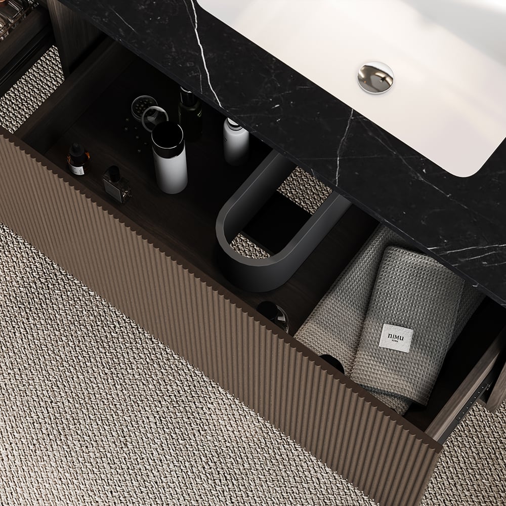 Bathroom drawer with toiletries and a towel on a marble countertop