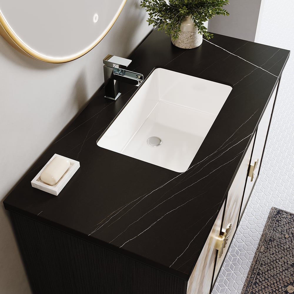 Bathroom vanity with black countertop, white sink, and decorative elements.