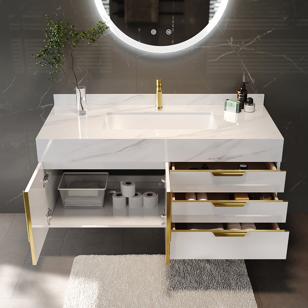 Bathroom vanity with marble countertop, gold fixtures, and open drawer revealing storage items.