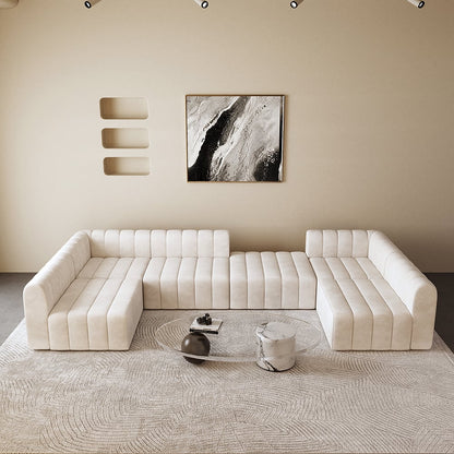 Modern living room with a off white sectional sofa, abstract art, and marble coffee table.
