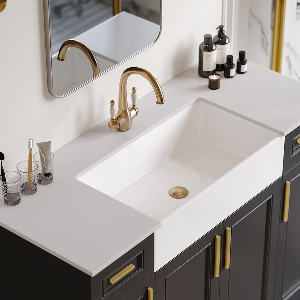 Bathroom vanity with white sink, gold faucet, and dark cabinets.