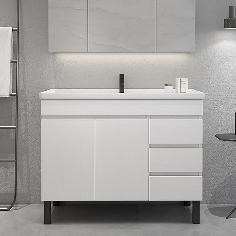 Bathroom vanity with white countertop and cabinets in a modern bathroom setting.